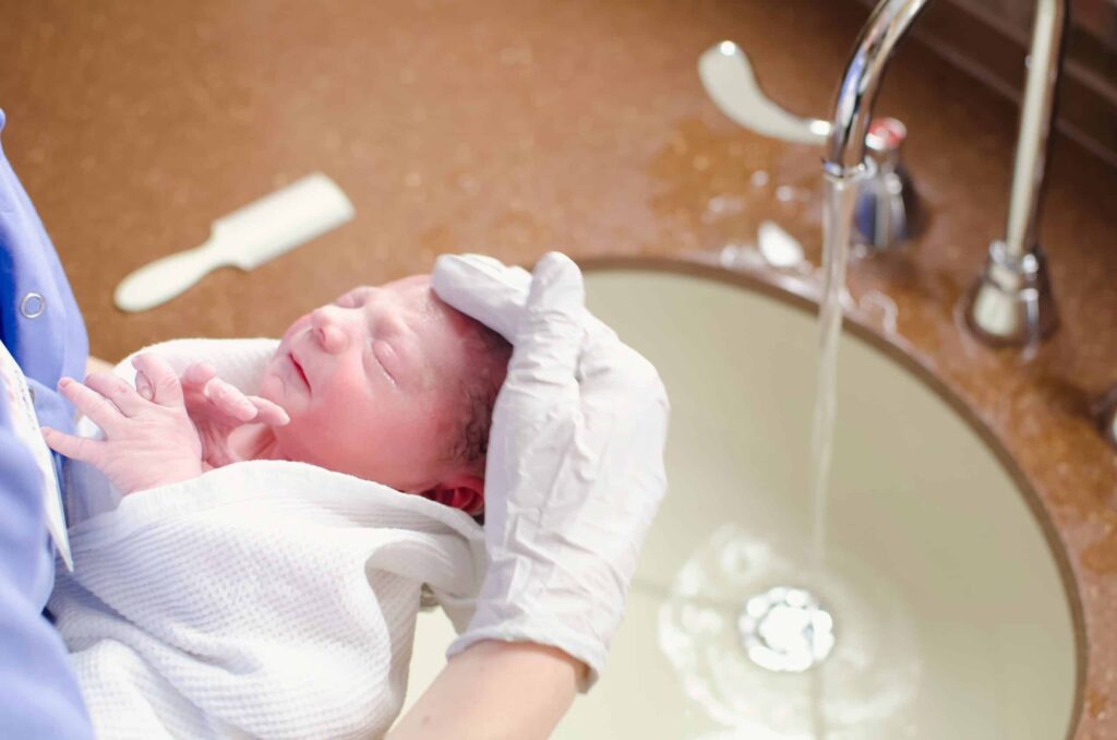 a person bathing a baby