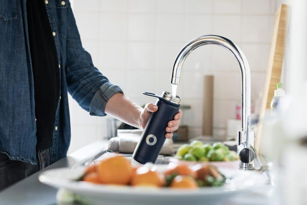 Person filling up drink bottle from tap