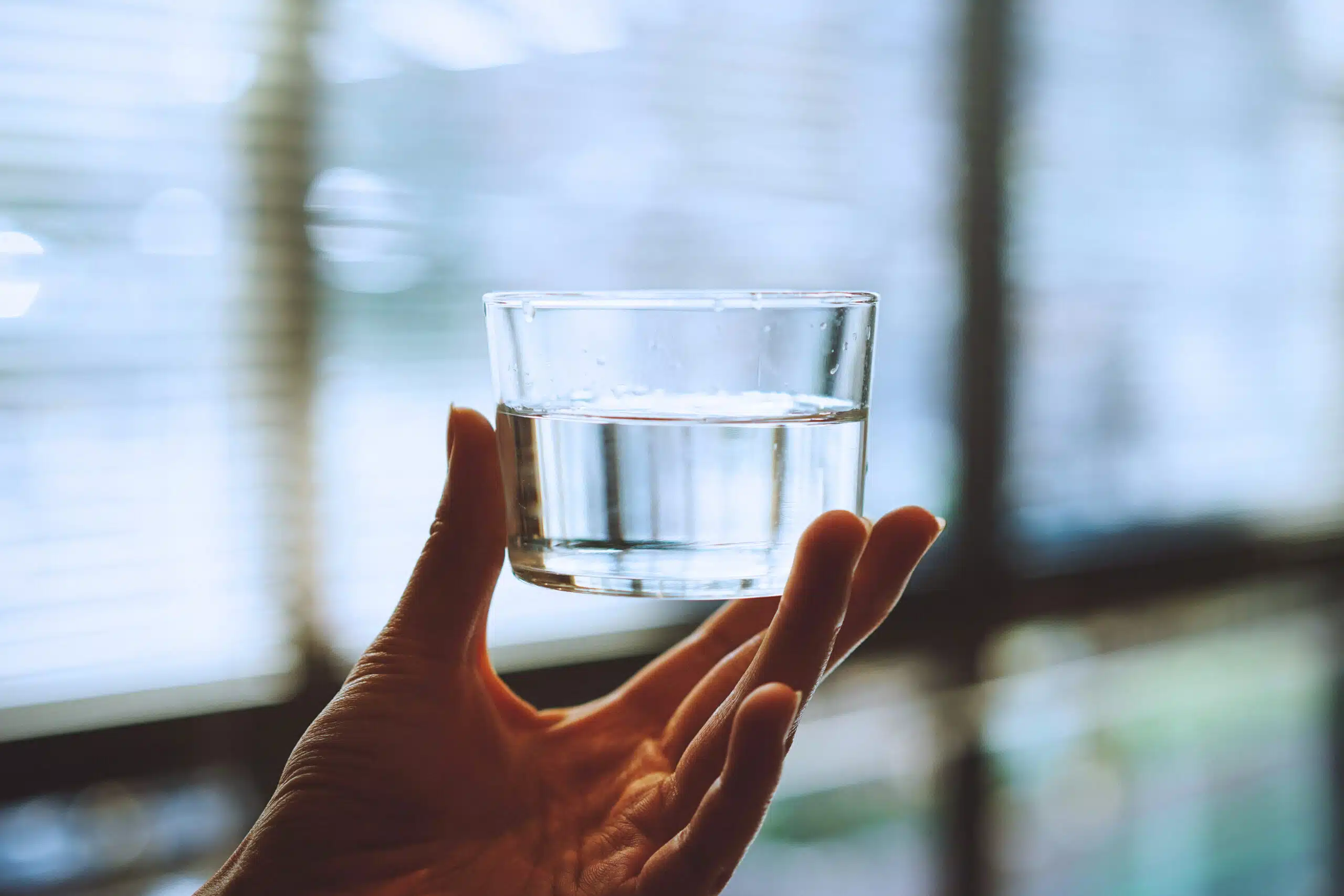 Hand holding a cup of drinking water